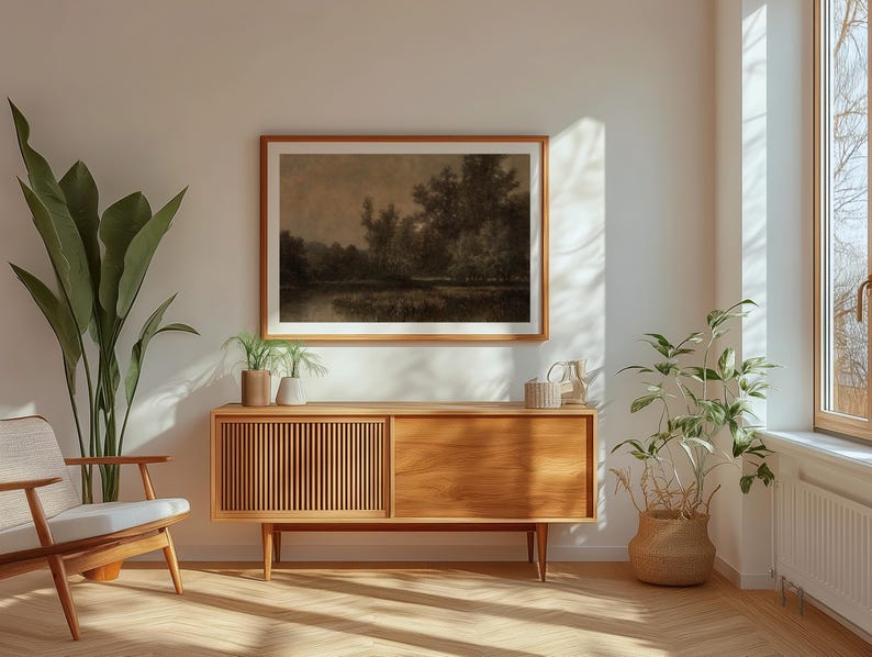 Pu&ograve; includere: Un credenza in legno con una finitura in legno chiaro e un piano in legno scuro. La credenza ha due ante e due cassetti. Un dipinto paesaggistico incorniciato &egrave; appeso al muro sopra la credenza. Una pianta in vaso si trova sul pavimento accanto alla credenza.