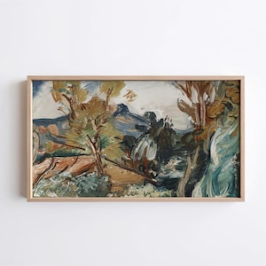 May include: A rectangular landscape painting in a light wood frame featuring expressive brushstrokes in shades of brown, green, blue, and white. The artwork depicts a natural scene with trees, foliage, and a distant mountain range under a sky.