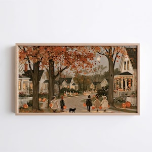 May include: A framed horizontal wall art print depicting a neighborhood street scene during autumn at dusk. Children in costumes walk along a path carrying orange pumpkins, accompanied by a black cat, with houses and trees in warm fall colors.