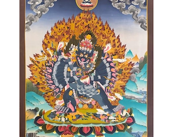 May include: A vibrant painting depicting a multi-armed deity with a fierce expression, surrounded by flames. The figure is dark blue, seated on a lotus flower, with a backdrop of mountains and a cloudy sky. The artwork is framed in a dark brown border.