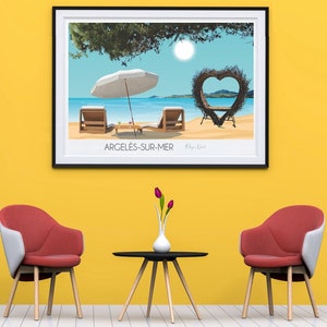 Könnte beinhalten: Eine gerahmte Illustration einer Strandszene mit zwei Liegestühlen, einem Sonnenschirm und einem herzförmigen Torbogen aus Ästen. Der Text "Argelès-sur-Mer" ist unter dem Bild gedruckt.