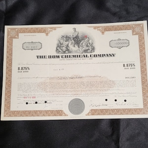 May include: A vintage stock certificate for The Dow Chemical Company, dated May 1, 2000. The certificate is for 8.875% debenture due 2000, with a face value of one hundred thousand dollars. The certificate is registered to RU 1817 and is signed by the Treasurer and President of the company.