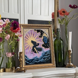 May include: A framed painting with a gold frame depicting a black bird flying through a purple and blue sky with a golden sun and a heart shaped flame. The painting is on a white mantel with flowers in vases.