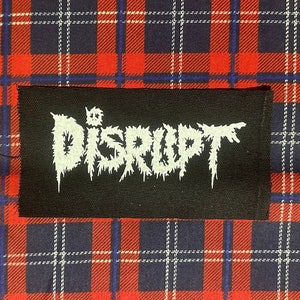 May include: Black patch with white text that reads "The Disrupt" in a stylized font.