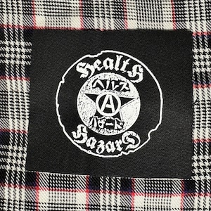 May include: Black and white patch with a circle design. The circle has the text "Sealt's Bazaar" and a star with the letter "A" inside. The text "Ailz" is above the star and the text "バザー" is below the star.