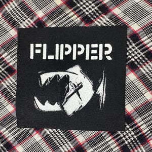 May include: Black and white iron-on patch with the word "FLIPPER" in white letters and a black and white graphic of a creature's mouth with teeth.