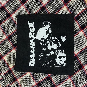 May include: Black and white Discharge band patch with the band's name in white lettering and a graphic of the band members.