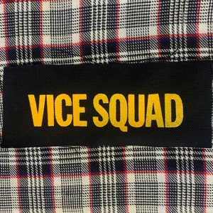 May include: Black patch with the words "VICE SQUAD" in yellow letters.