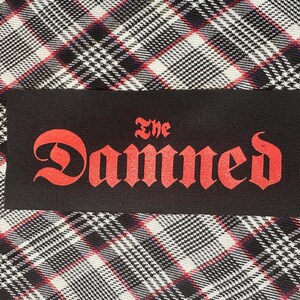 May include: Black and red embroidered patch with the text "The Damned" in a gothic font.