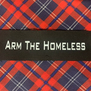 May include: Black fabric patch with white text that reads "ARM THE HOMELESS".