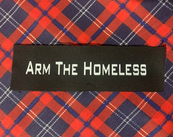 May include: Black fabric patch with white text that reads "ARM THE HOMELESS".