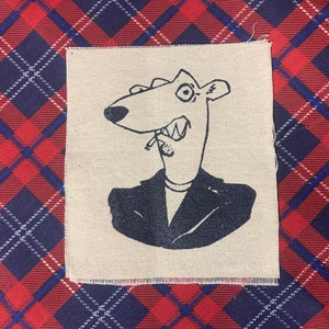 May include: A black and white illustration of a cartoon animal wearing a suit and smoking a cigarette. The animal has a long snout and large ears. The illustration is printed on a beige fabric patch.