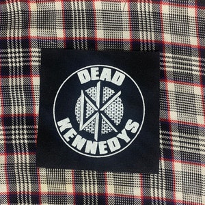 May include: Black patch with a white circle containing the text "DEAD KENNEDYS" and a stylized starburst design.