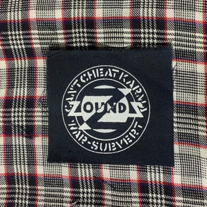 May include: A black and white patch with the text "Can't Cheat Karma" and "Sound Subvert" in a circle around a stylized "Z" with the word "Sound" inside.