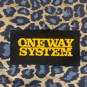 May include: Black fabric patch with the words "ONEWAY SYSTEM" in yellow lettering.
