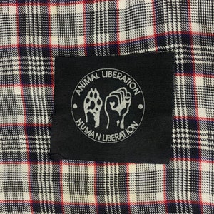 May include: Black and white patch with the text "Animal Liberation Human Liberation" in a circle with a paw print and fist inside.