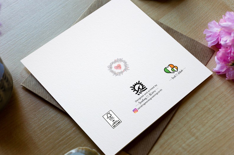 May include: A white card with a black and white sun and wave design. The text "Designed and printed by Sending & Making - sendingandmakinggreetingcards" is below the design. There is a small green and orange heart with the text "Irish Pride" below it. There is a small pink heart with a floral wreath around it. There is a small black and white stamp with the text "FSC" in the center.