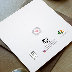 May include: A white card with a black and white sun and wave design. The text "Designed and printed by Sending & Making - sendingandmakinggreetingcards" is below the design. There is a small green and orange heart with the text "Irish Pride" below it. There is a small pink heart with a floral wreath around it. There is a small square stamp with the text "FSC" in it.