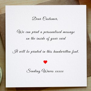 May include: A white card with black text that reads "Dear Customer, We can print a personalised message on the inside of your card. It will be printed in this handwritten font. Sending Waves xxxxx". A red heart is printed below the text.