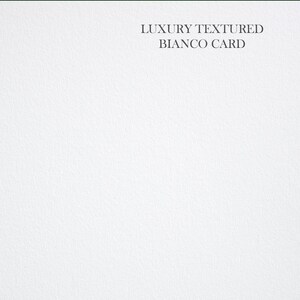 May include: A close-up of a white textured card with the text "LUXURY TEXTURED BIANCO CARD" printed in black.
