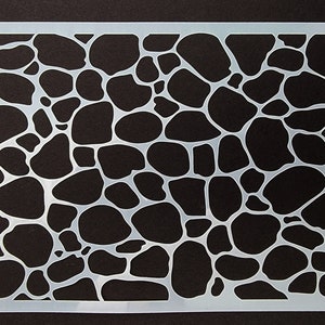 Puede incluir: Una plantilla de plástico blanco con un patrón de formas redondeadas irregulares que se asemejan a piedras. La plantilla está diseñada para crear una textura de piedra en las superficies.