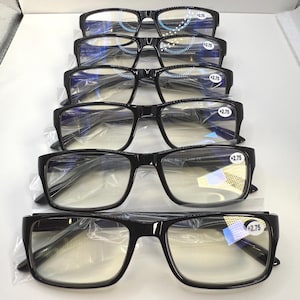 May include: A stack of six black-framed reading glasses with clear lenses. Each pair has a +2.75 strength sticker on the lens. The glasses are rectangular and appear to be new, still in their protective plastic.
