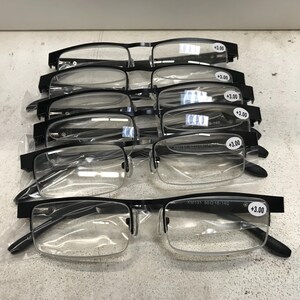 May include: A set of six black reading glasses with clear lenses. Each pair has a +3.00 magnification label.