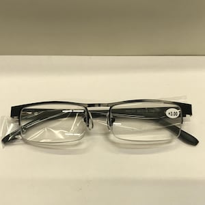 May include: Black metal frame reading glasses with clear lenses. The glasses have a label that says "XM1131 50D18-140 +3.00".