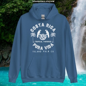 May include: A blue hoodie with a white graphic design featuring the text "Costa Rica - Tropical Paradise Pura Vida Island Palm Co." and a sloth with two parrots.