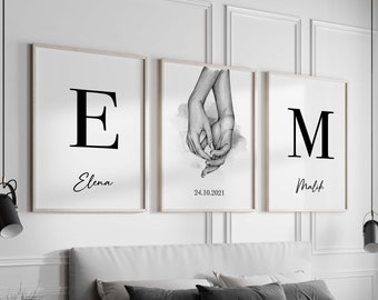 Peut inclure: Trois impressions en noir et blanc avec les lettres E, M et un dessin de deux mains se tenant l'une l'autre. La lettre E porte le nom Elena en dessous, la lettre M porte le nom Malik en dessous et le dessin des mains porte la date 24.10.2021 en dessous.
