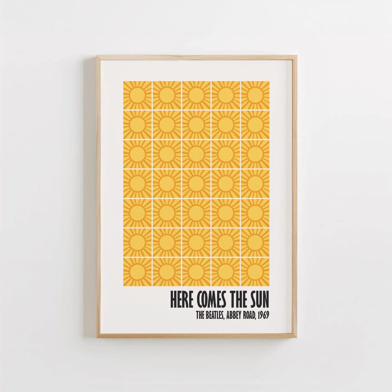 Peut inclure: Impression d'art encadr&eacute;e avec un motif r&eacute;p&eacute;t&eacute; de soleils jaunes sur fond blanc. Le texte "HERE COMES THE SUN" est imprim&eacute; en noir, avec "THE BEATLES, ABBEY ROAD, 1969". L'impression est dans un cadre en bois brun clair.