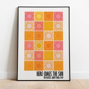 Peut inclure: Une affiche encadr&eacute;e avec une grille d'illustrations de soleil aux couleurs rose, orange et jaune. Le texte "HERE COMES THE SUN" est affich&eacute; en dessous, avec "THE BEATLES, ABBEY ROAD, 1969".