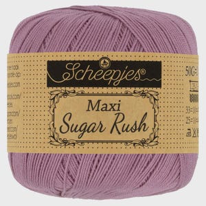 Könnte beinhalten: Kugel aus lavendelfarbener Wolle mit braunem Etikett. Auf dem Etikett steht "Scheepjes Maxi Sugar Rush". Das Garn ist eng gewickelt und wirkt weich, ideal für Strick- oder Häkelprojekte. Gewicht 50g.