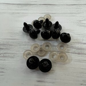 Puede incluir: Un conjunto de ojos de seguridad de pl&aacute;stico negro con arandelas de pl&aacute;stico transparente. Los ojos tienen un aspecto brillante y redondeado, dise&ntilde;ados para manualidades y fabricaci&oacute;n de juguetes. Las arandelas son planas y circulares.