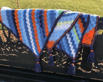 Manta de bebé tejida a crochet hecha a mano: rayas azules y naranjas llamativas, borlas