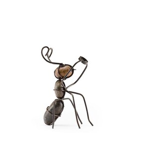 May include: A handcrafted metal ant sculpture with a unique design. The ant's body is formed from smooth, rounded stones, while its legs and antennae are made of dark metal wire. The sculpture is set against a plain white background.
