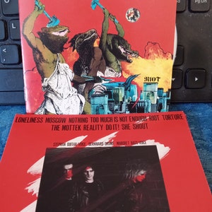 May include: Red and black album cover with a band name "MOTTEK" in large white letters. The album cover features a band photo of three people with a red background. The album title is "LONELINESS MOSCOW NOTHING TOO MUCH IS NOT ENOUGH RIOT TORTURE THE MOTTEK REALITY DO IT! SHE SHOUT".