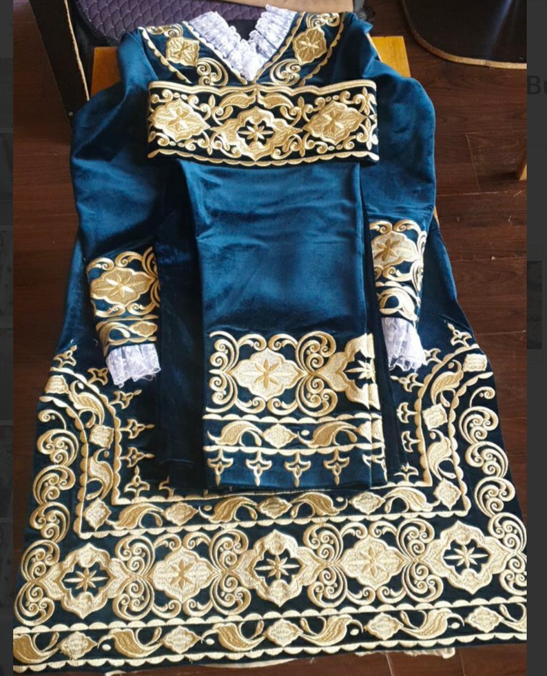 May include: A teal velvet robe with gold embroidery. The robe has long sleeves and a collar. The embroidery is intricate and features floral designs.