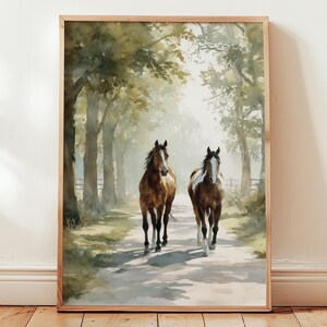May include: Watercolor painting of two brown horses walking down a path lined with trees. The horses are the focal point, with one having a white blaze. The artwork is framed in a light wood frame, adding a rustic touch to the scene.