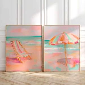 May include: Two framed beach-themed paintings. One depicts a beach chair on a sandy shore, the other a striped umbrella. The artwork uses a pastel color palette of pink, orange, and teal, evoking a serene coastal scene.