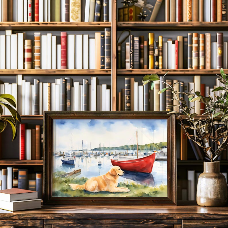 Puede incluir: Una pintura de acuarela de un perro golden retriever sentado en una colina cubierta de hierba con vistas a un puerto con veleros y un bote de remos rojo. La pintura est&aacute; enmarcada en un marco de madera oscura.