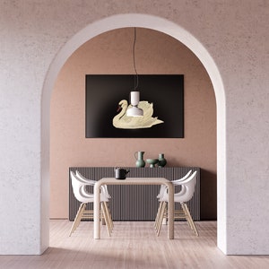 K&ouml;nnte beinhalten: Ein wei&szlig;er Esstisch mit vier wei&szlig;en St&uuml;hlen steht in einem Raum mit einem wei&szlig;en Torbogen. Ein schwarz gerahmtes Bild eines wei&szlig;en Schwans h&auml;ngt an der Wand &uuml;ber dem Tisch. Eine wei&szlig;e Pendelleuchte h&auml;ngt &uuml;ber dem Tisch.