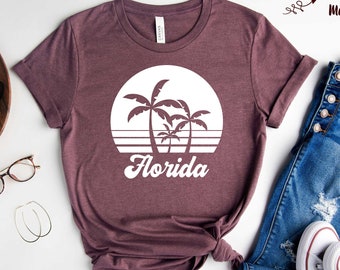 May include: A heather maroon t-shirt with a white graphic of palm trees and a sunset with the text "Florida" in a retro font.