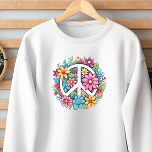 May include: White sweatshirt with a peace sign surrounded by colorful flowers. The peace sign is white and the flowers are pink, yellow, blue, and green.