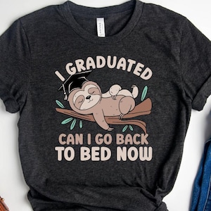 May include: A dark gray t-shirt with a graphic of a sloth wearing a graduation cap and the text "I Graduated Can I Go Back To Bed Now".