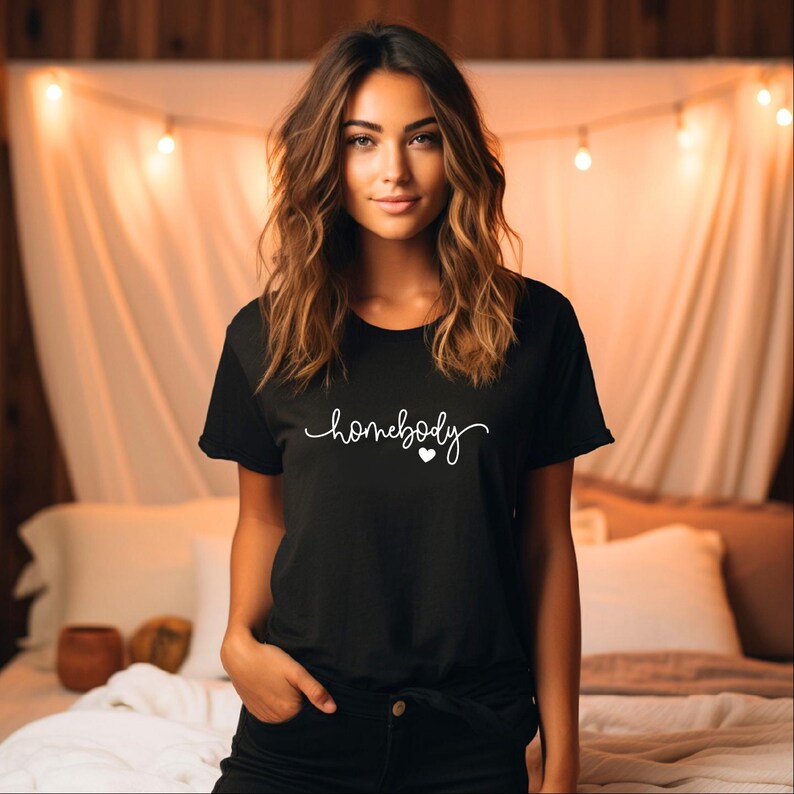 May include: A black t-shirt with the text "homebody" in white cursive lettering and a small white heart.