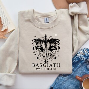 a sweatshirt with a graphic of a mask and a book