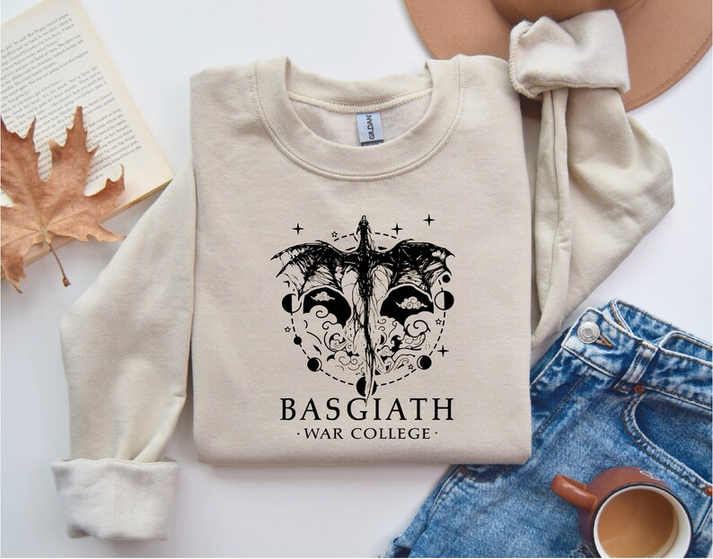 a sweatshirt with a graphic of a mask and a book