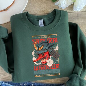 a green sweatshirt with an image of a demon on it