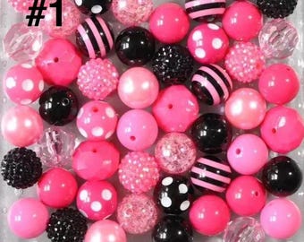 May include: A collection of pink, black, and clear beads in various sizes and textures. Some beads are solid pink, others have white polka dots or black stripes. Several beads are black with a textured surface. The image includes the text "#1".